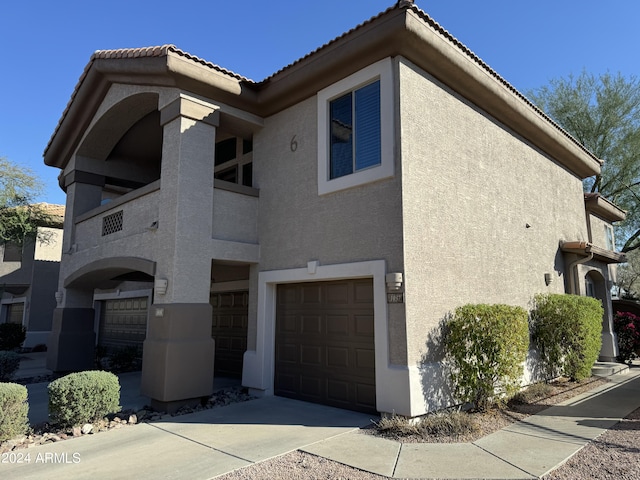14000 N 94th St Unit 1037, Scottsdale, AZ 85260 - view of front of property with concrete driveway, a balcony, a tile roof, stucco siding, and a garage