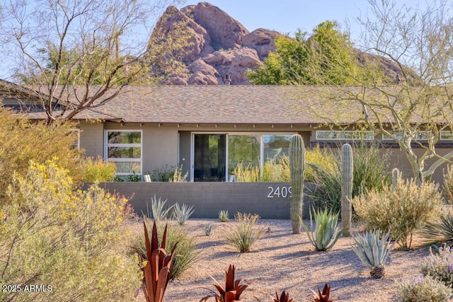 view of front of property featuring roof with shingles, a mountain view, and stucco siding