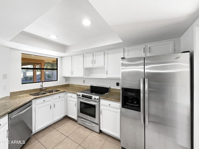 12342 S Shoshoni Dr, Phoenix, AZ 85044 - kitchen featuring stainless steel appliances, a sink, a tray ceiling, white cabinetry, and light tile patterned floors