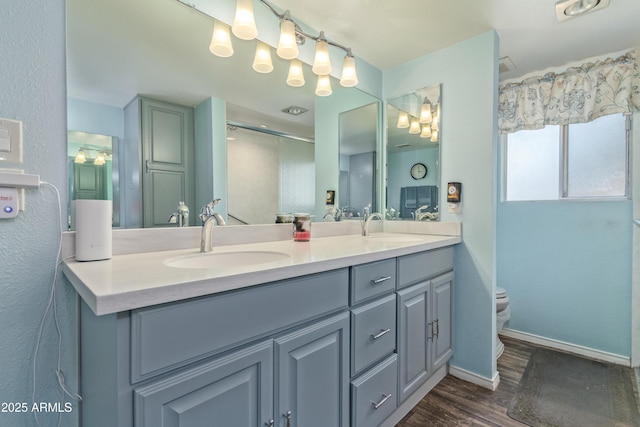 8540 N 43rd Dr, Glendale, AZ 85302 - full bathroom with wood finished floors, double vanity, toilet, and baseboards