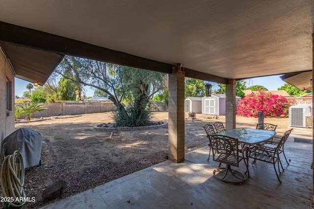 8540 N 43rd Dr, Glendale, AZ 85302 - view of patio with a shed, outdoor dining space, a fenced backyard, an outdoor structure, and central AC unit