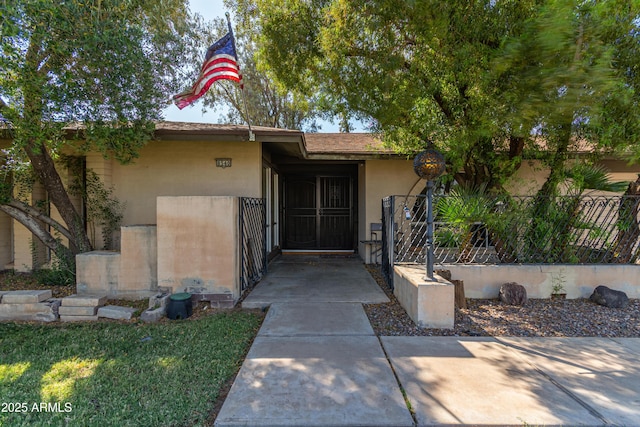 8540 N 43rd Dr, Glendale, AZ 85302 - view of exterior entry featuring fence, a gate, and stucco siding
