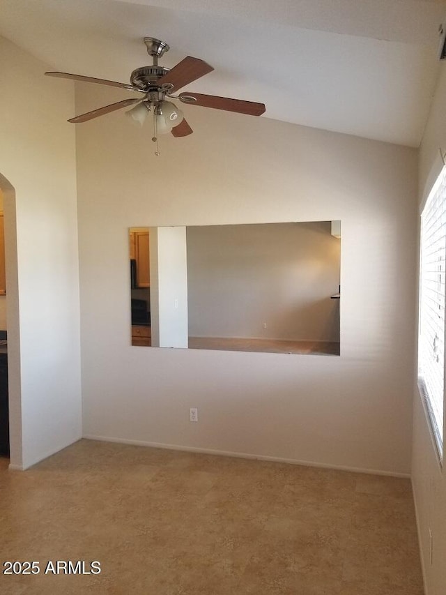 unfurnished room with carpet floors, arched walkways, and ceiling fan