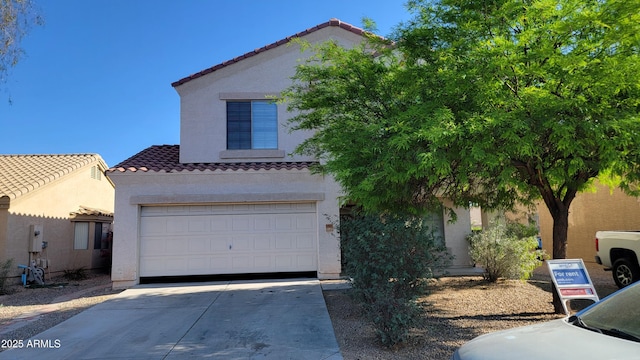 view of front of home featuring an attached garage, stucco siding, a tiled roof, and driveway