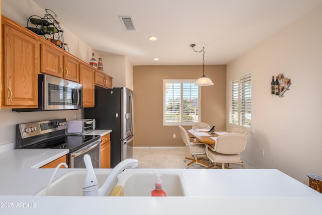 kitchen featuring appliances with stainless steel finishes, sink, and decorative light fixtures