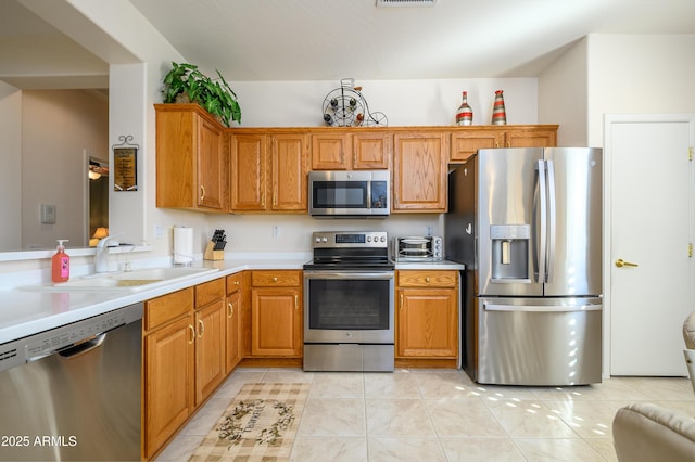 kitchen with sink, stainless steel appliances, and light tile patterned flooring