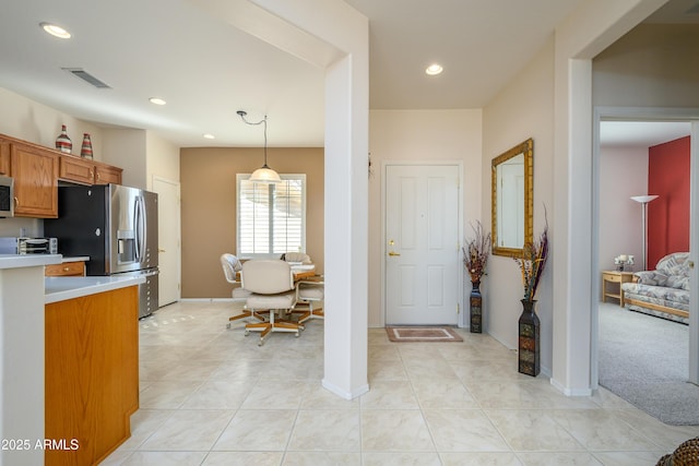 kitchen featuring light tile patterned flooring, stainless steel appliances, and decorative light fixtures