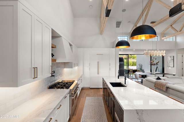 1013 W Ardmore Rd, Phoenix, AZ 85041 - kitchen with a sink, high end range, open shelves, a high ceiling, and light wood-style flooring