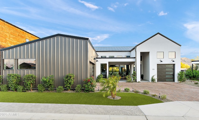 1013 W Ardmore Rd, Phoenix, AZ 85041 - view of front of house with a front lawn, a garage, metal roof, a standing seam roof, and decorative driveway