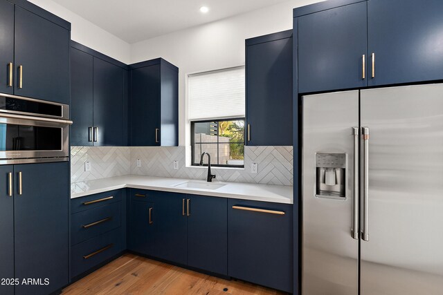 1013 W Ardmore Rd, Phoenix, AZ 85041 - kitchen featuring stainless steel appliances, blue cabinets, a sink, light countertops, and wood finished floors