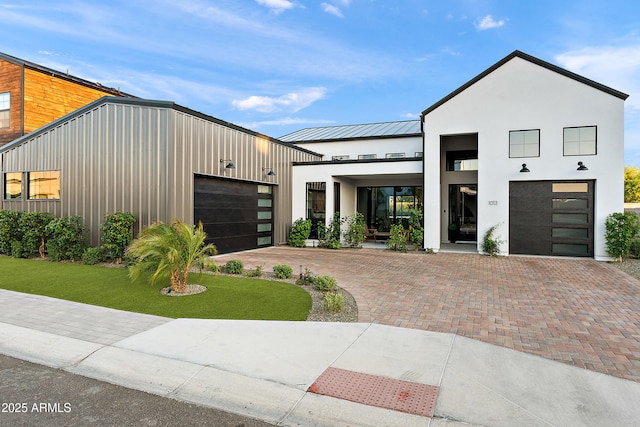 1013 W Ardmore Rd, Phoenix, AZ 85041 - contemporary home featuring a standing seam roof, a garage, stucco siding, metal roof, and a front lawn