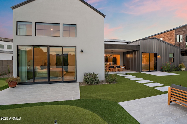 1013 W Ardmore Rd, Phoenix, AZ 85041 - back of property at dusk with a patio, a ceiling fan, a yard, and stucco siding