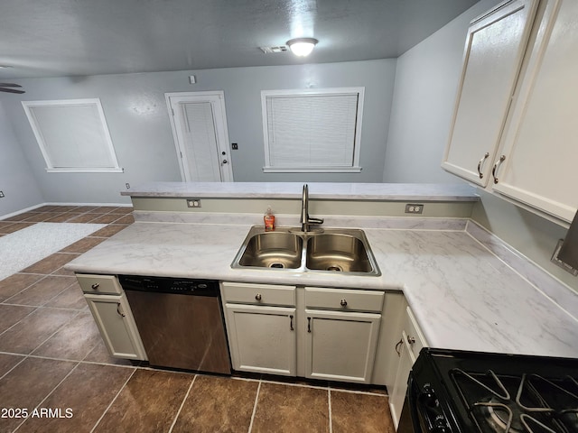 kitchen with a sink, a peninsula, black gas stove, stainless steel dishwasher, and dark tile patterned flooring