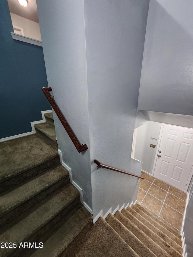 staircase featuring carpet floors and baseboards