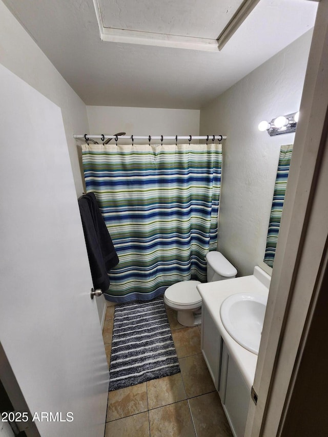 bathroom with vanity, a textured wall, tile patterned flooring, and toilet