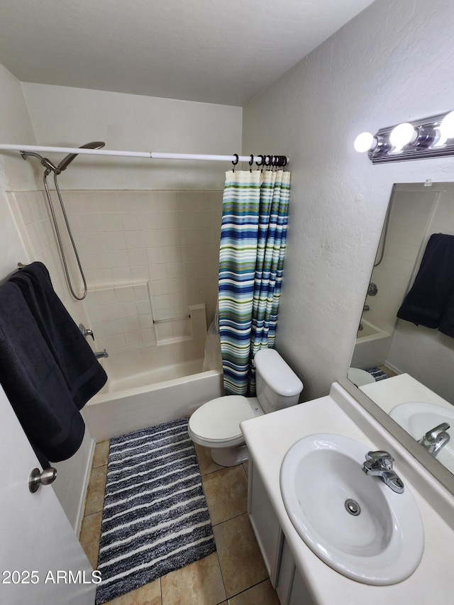 bathroom featuring vanity, a textured wall, toilet, shower / bathtub combination with curtain, and tile patterned floors