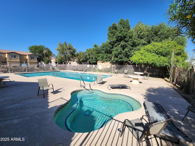 pool with a patio and fence