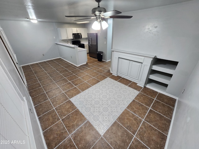 kitchen with ceiling fan, dark tile patterned flooring, stainless steel microwave, a peninsula, and refrigerator with ice dispenser