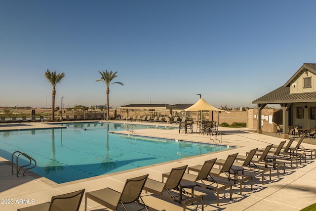 pool with a patio area and fence