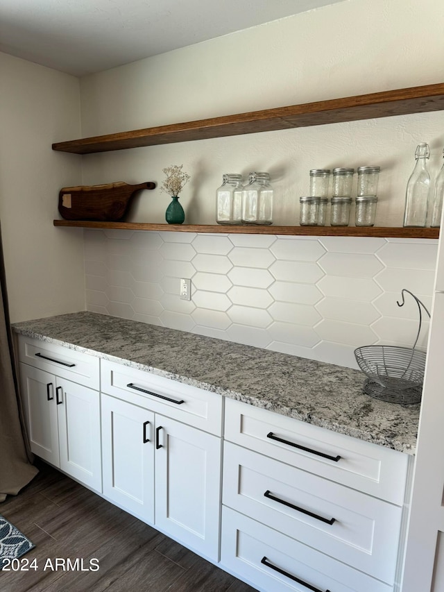 bar with white cabinets, light stone countertops, dark wood-type flooring, and tasteful backsplash