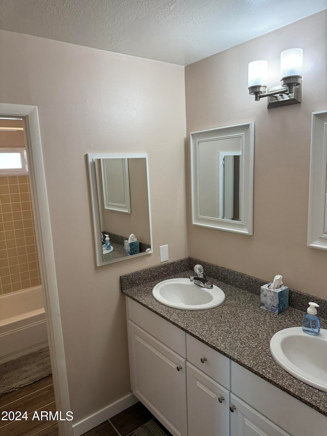 bathroom with vanity, a bathtub, tile patterned flooring, and a textured ceiling