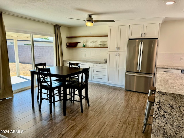 dining room with ceiling fan, a textured ceiling, and dark wood-type flooring