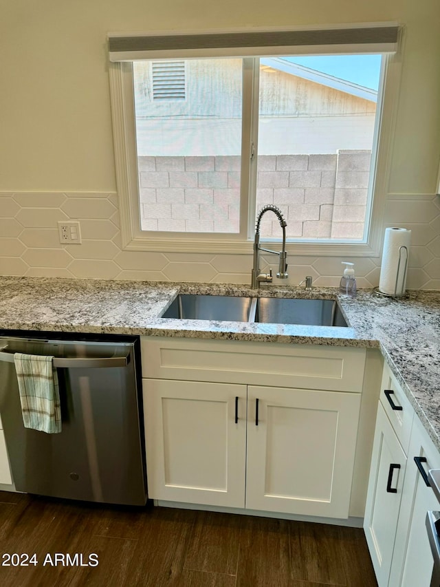 kitchen with dark hardwood / wood-style floors, sink, stainless steel dishwasher, and white cabinetry