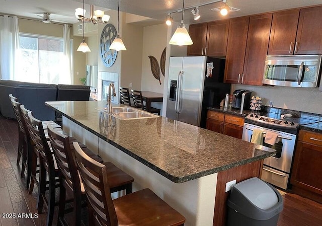 6605 N 93rd Ave Unit 1071, Glendale, AZ 85305 - kitchen featuring stainless steel appliances, a sink, dark wood-style floors, a breakfast bar, and decorative light fixtures