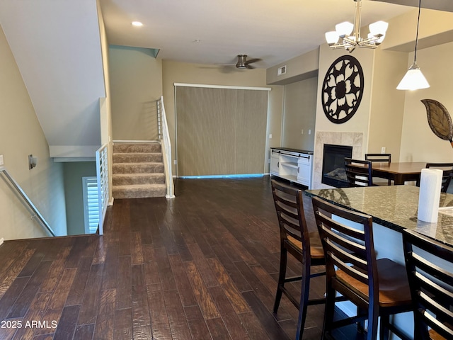 6605 N 93rd Ave Unit 1071, Glendale, AZ 85305 - kitchen with hardwood / wood-style floors, a tiled fireplace, ceiling fan, a chandelier, and hanging light fixtures