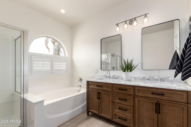 896 E Indian Wells Pl, Chandler, AZ 85249 - bathroom featuring double vanity, a garden tub, wood finished floors, and an enclosed shower