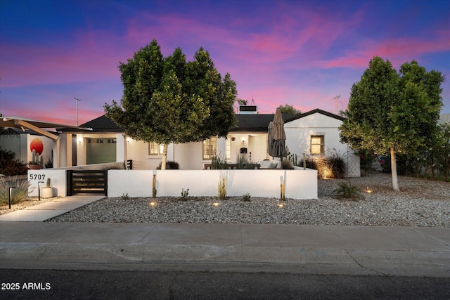 5707 N 12th Pl, Phoenix, AZ 85014 - view of front of home with a fenced front yard, a garage, driveway, and stucco siding