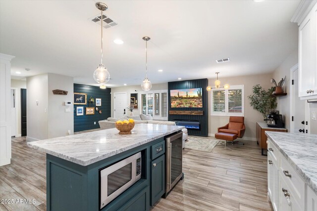 5707 N 12th Pl, Phoenix, AZ 85014 - kitchen with beverage cooler, white microwave, white cabinetry, baseboards, and open floor plan