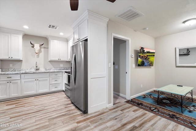 5707 N 12th Pl, Phoenix, AZ 85014 - kitchen featuring stainless steel appliances, a sink, recessed lighting, light wood-style flooring, and white cabinetry