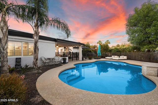 5707 N 12th Pl, Phoenix, AZ 85014 - pool at dusk featuring an outdoor living space, a patio area, and a fenced backyard