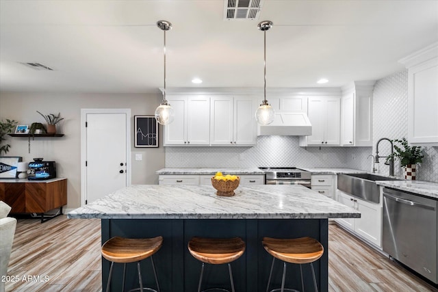 5707 N 12th Pl, Phoenix, AZ 85014 - kitchen featuring appliances with stainless steel finishes, a sink, a center island, and a breakfast bar