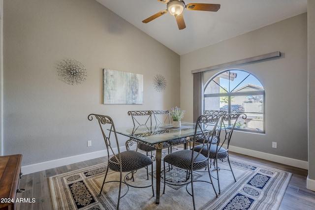 dining space featuring ceiling fan, light wood-type flooring, and vaulted ceiling