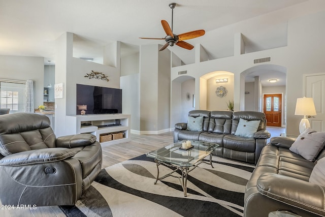 living room featuring ceiling fan, plenty of natural light, high vaulted ceiling, and light hardwood / wood-style flooring