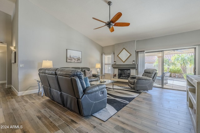 living room featuring a fireplace, wood-type flooring, high vaulted ceiling, and ceiling fan