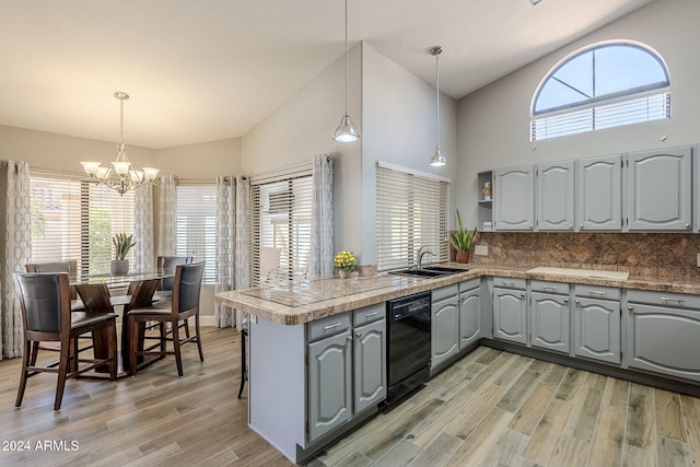 kitchen featuring kitchen peninsula, pendant lighting, black dishwasher, and high vaulted ceiling