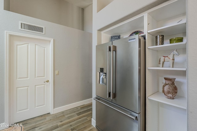 kitchen featuring stainless steel fridge with ice dispenser and light wood-type flooring