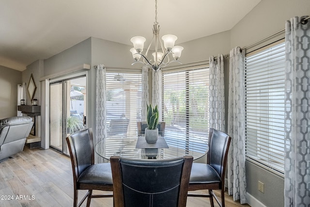 dining area featuring light wood-type flooring, an inviting chandelier, and plenty of natural light