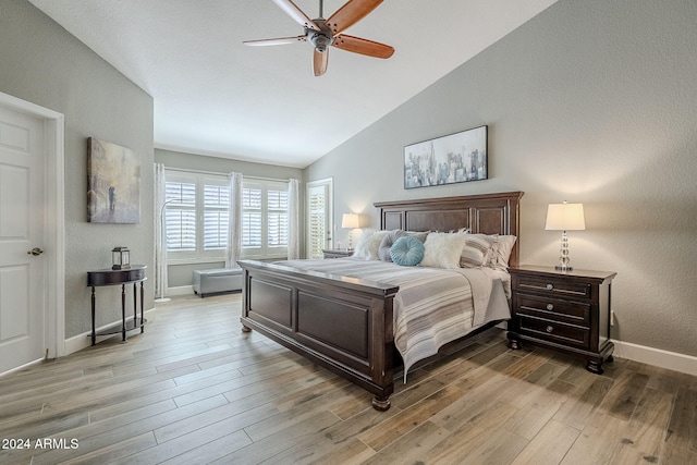 bedroom featuring ceiling fan, light wood-type flooring, and vaulted ceiling