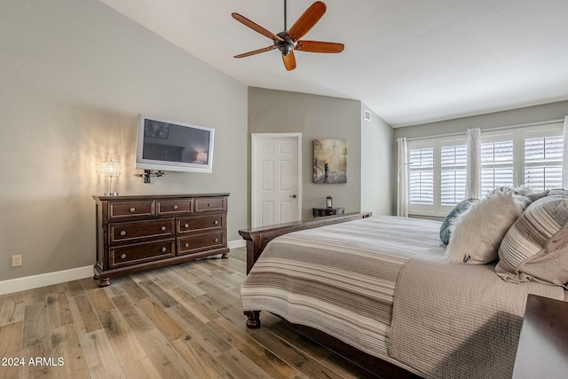 bedroom with ceiling fan, lofted ceiling, and light wood-type flooring