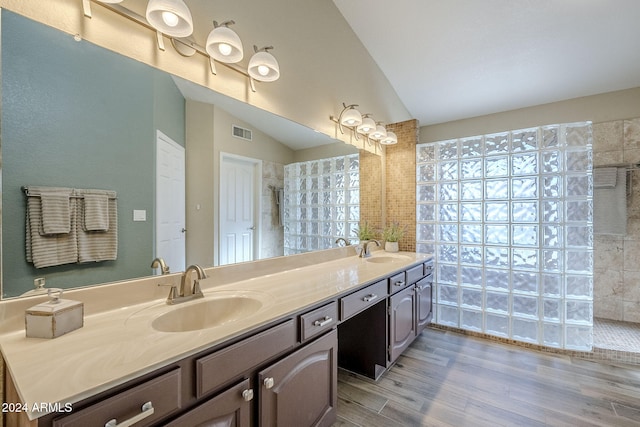 bathroom featuring hardwood / wood-style flooring, vanity, and lofted ceiling