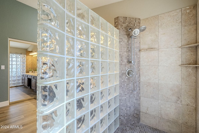 bathroom with wood-type flooring and tiled shower