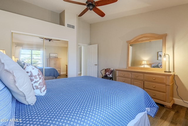 bedroom featuring a closet, dark hardwood / wood-style floors, and ceiling fan