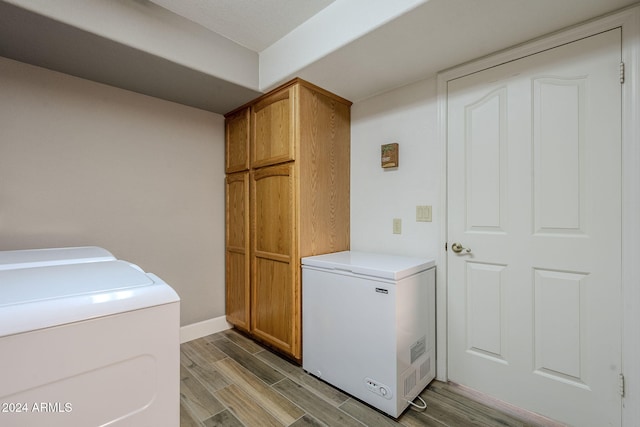 laundry area featuring washer and dryer, cabinets, and light wood-type flooring