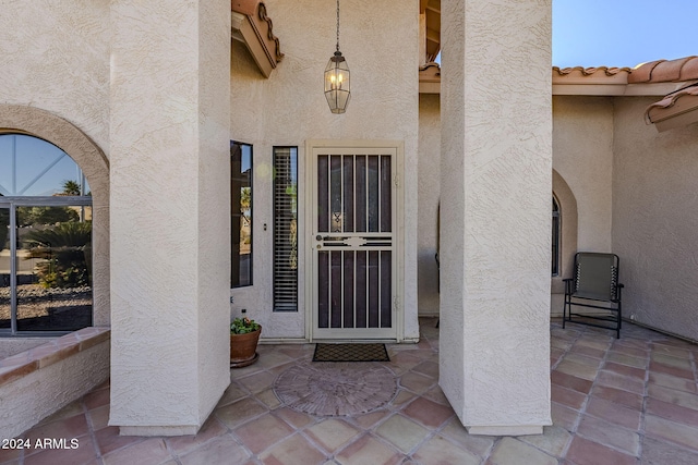 view of exterior entry featuring a patio area