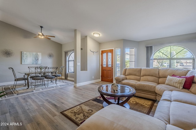 living room featuring lofted ceiling, ceiling fan, and light wood-type flooring