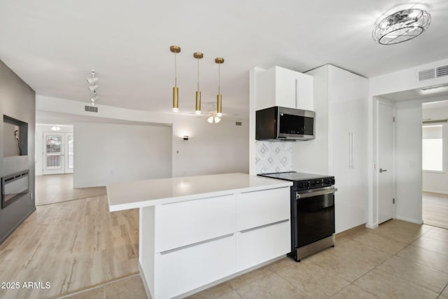 kitchen featuring pendant lighting, french doors, white cabinets, appliances with stainless steel finishes, and tasteful backsplash